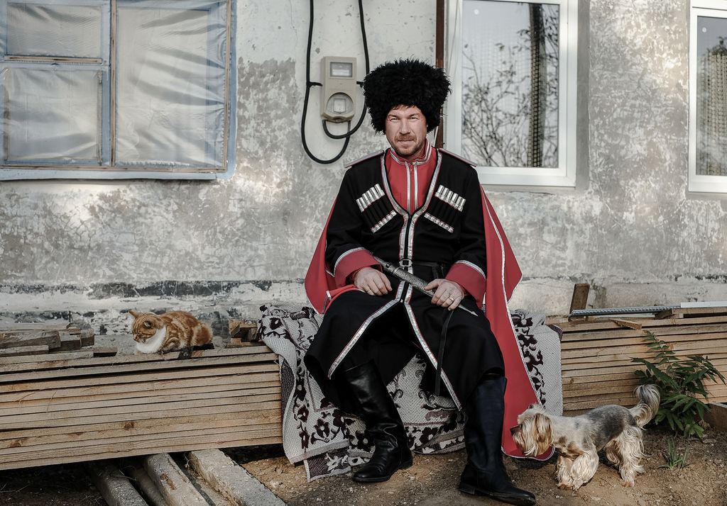 «Застывшая Кубань». Фотопроект о магическом реализме южного края, Сергей в казачьей форме во дворе своего дома в поселке Южный Склон. Он принял присягу и вступил в ряды кубанского казачества, переехав на Кубань с севера — discours.io
