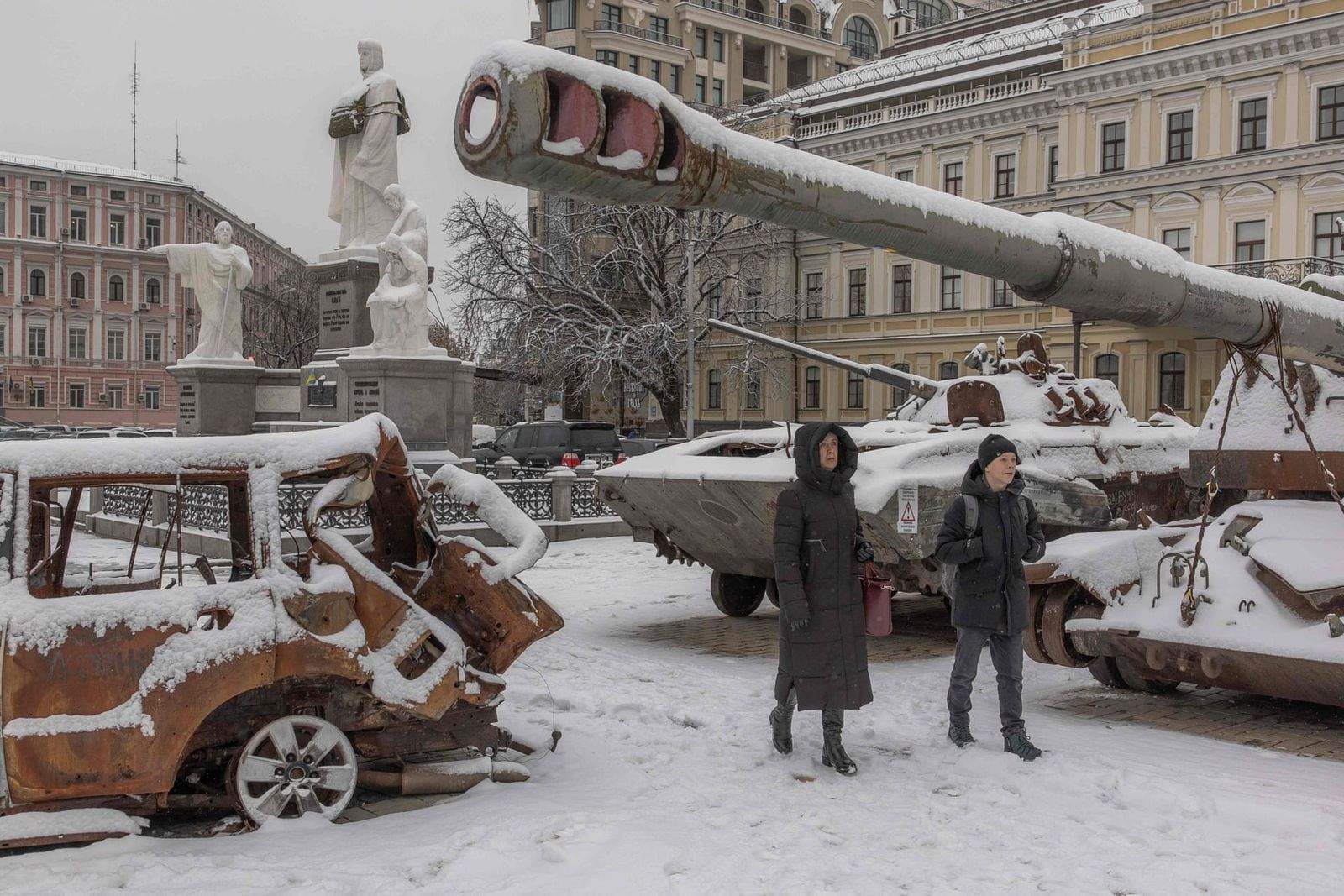 Жители Киева проходят мимо сгоревшей российской военной техники, засыпанной снегом, перед Михайловским собором. 22 ноября / Roman Pilipey / AFP