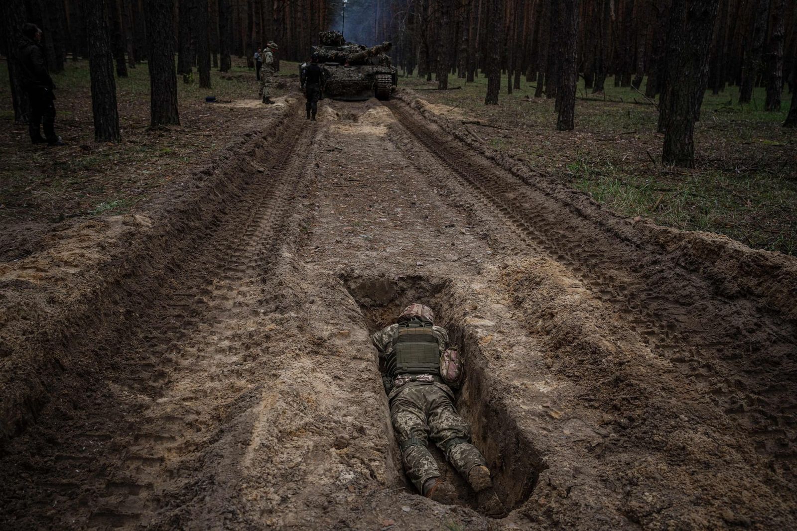 Украинский военный укрывается в траншее во время учений в Харькове. 2 мая. Dimitar Dilkoff / AFP / Getty Images / The Guardian