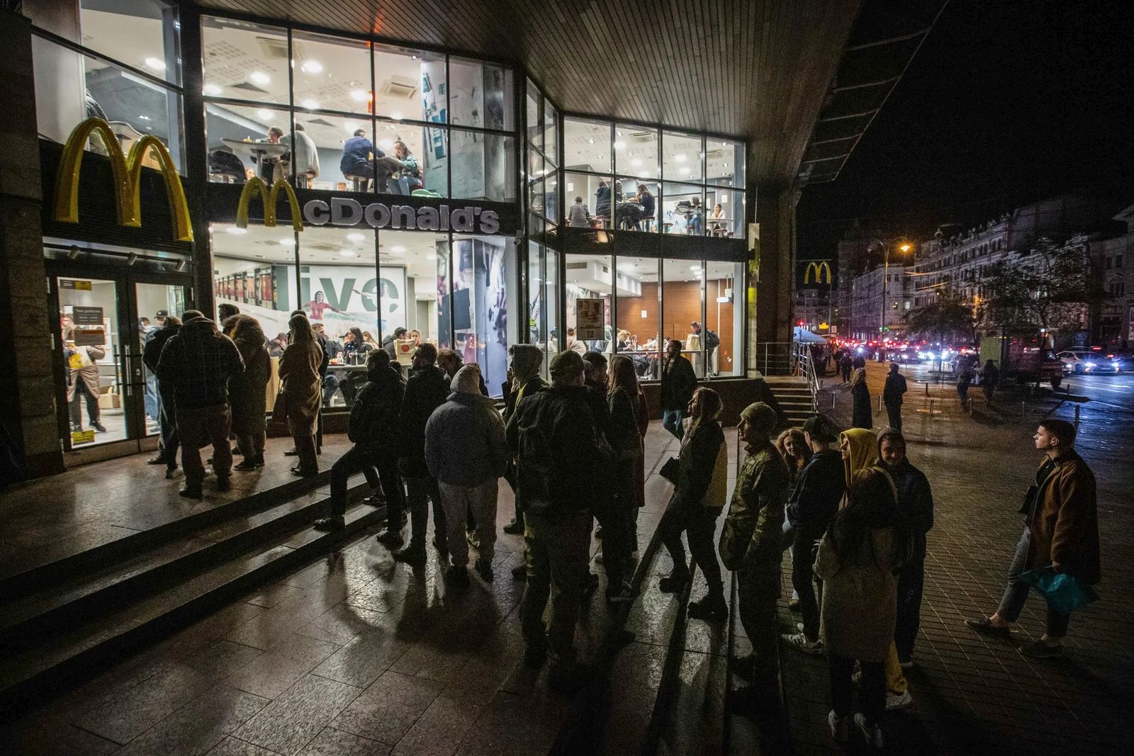 Люди стоят в очереди в ресторан McDonald’s на тёмной улице в центре Киева. По всей Украине ввели режим энергосбережения после атак России на украинскую энергетическую инфраструктуру. 23 октября / Oleksii Chumachenko / Sopa Images / Rex / Shutterstock