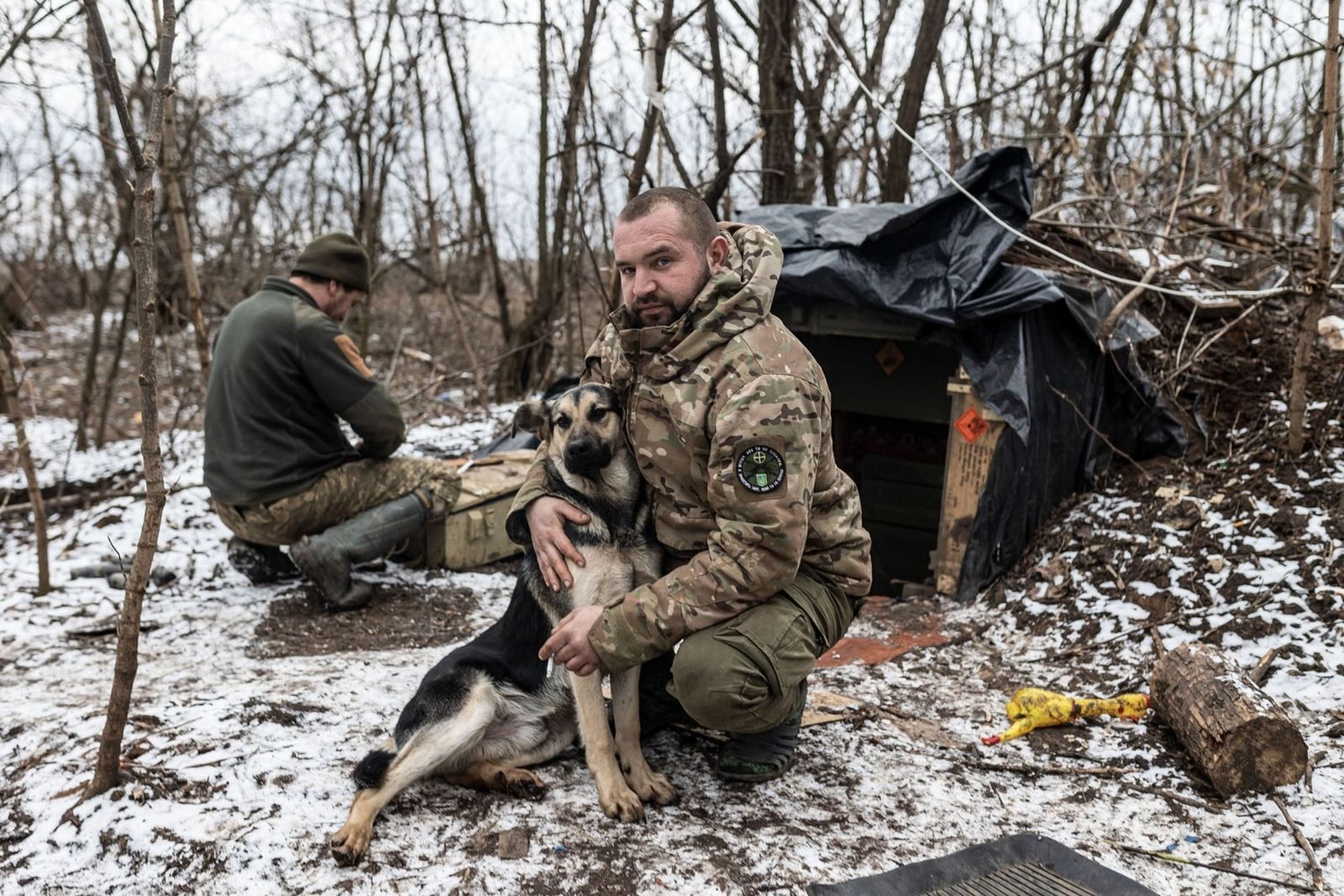 Украинский солдат играет с собакой на своей боевой позиции в направлении Бахмута. 20 февраля / Diego Herrera Carcedo / Anadolu