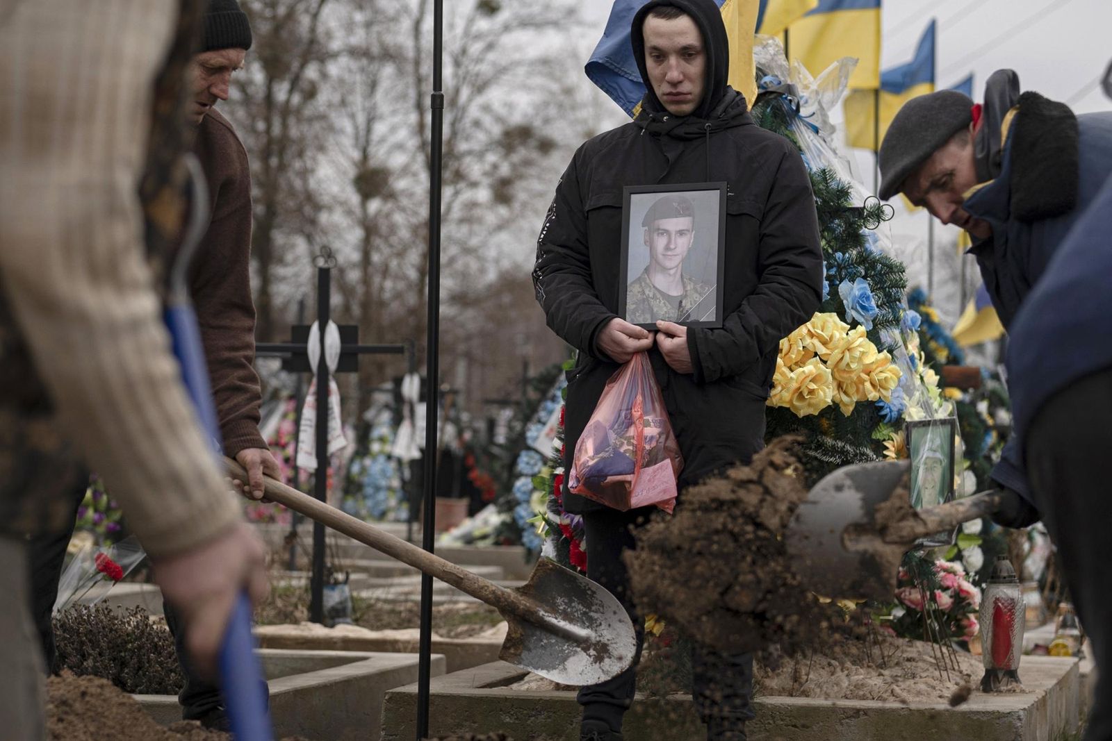 Сотрудники ритуальных служб закапывают гроб 22-летнего украинского солдата Даниила Лысенко во время похорон в Боярке под Киевом. 17 марта / Alexey Pavlishak / Reuters / Газета.ру 