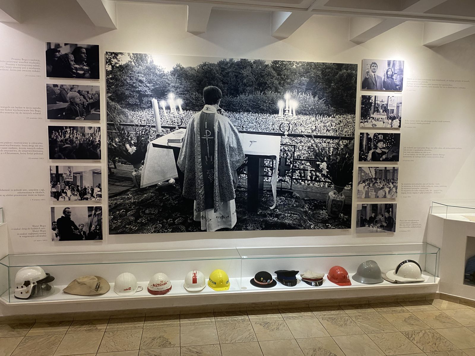 Экспозиция в&nbsp;музее Ежи Попелушко в&nbsp;Варшаве. «Капеллан Солидарности» запечатлён во&nbsp;время одной из&nbsp;служб за&nbsp;Отчество с&nbsp;балкона костела святого Станислава Костки. В&nbsp;витрине под фотографией выставлены каски подаренные рабочими в&nbsp;знак своей признательности и&nbsp;духовного единства с&nbsp;ксендзом. Фото автора.
