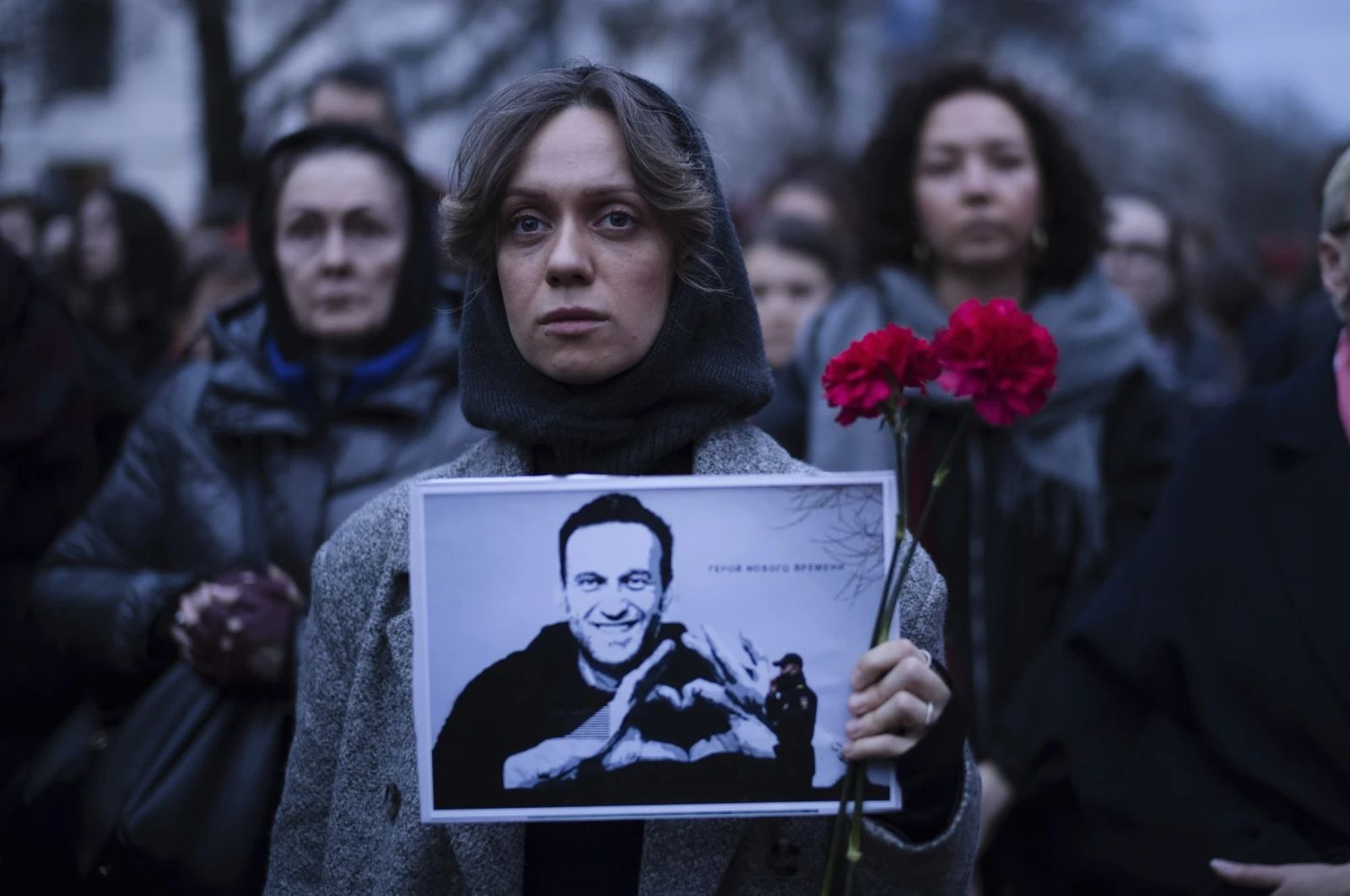 Женщина держит цветы и портрет лидера оппозиции Алексея Навального во время акции протеста перед российским посольством в Берлине. 16 февраля / Markus Schreiber / AP Photo