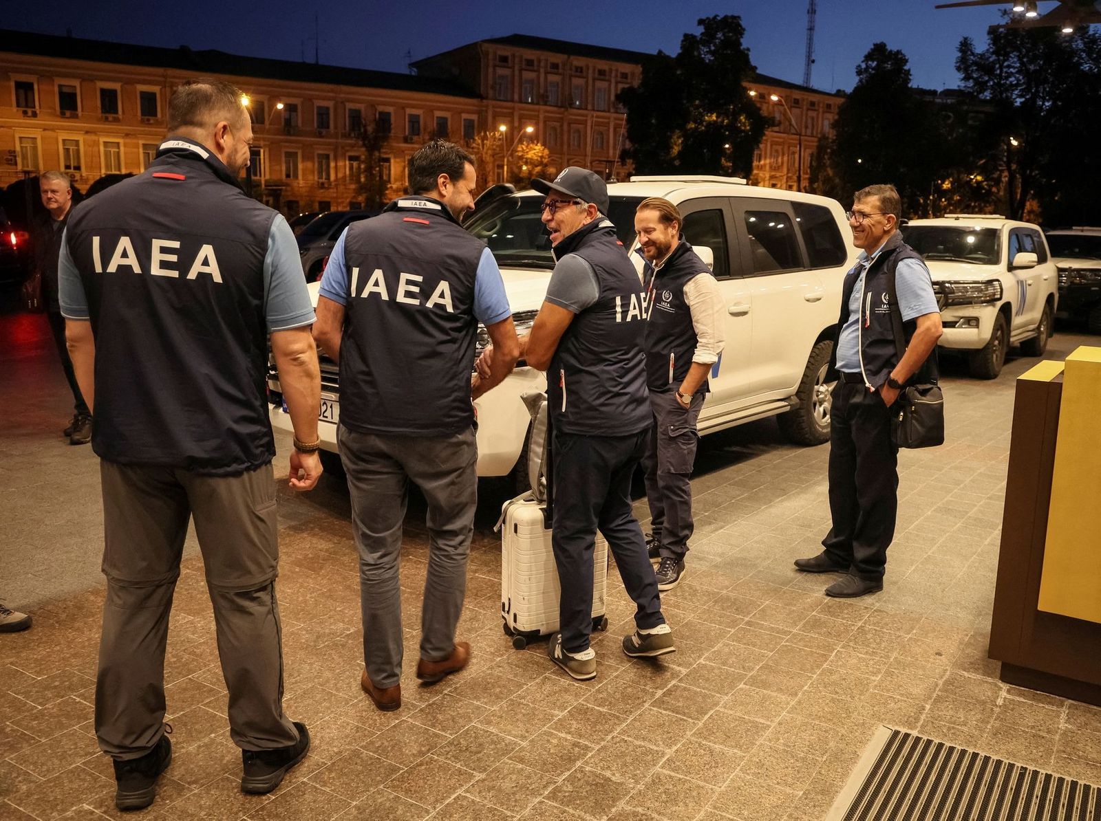 Члены миссии Международного агентства по атомной энергии (МАГАТЭ) стоят у автомобилей ООН возле отеля в Киеве. Экспедиция должна прибыть на Запорожскую атомную электростанцию. Накануне гендиректор МАГАТЭ Рафаэль Гросси встретился с президентом Украин