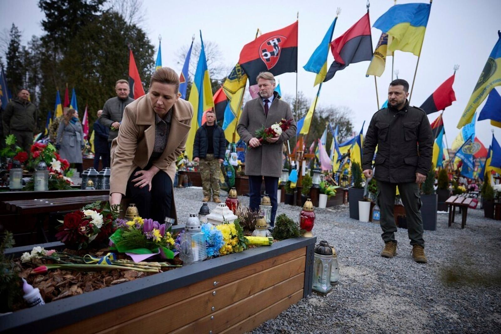 Президент Украины Владимир Зеленский, премьер-министр Дании Метте Фредериксен (слева) и её муж Бо Тенгберг отдают дань уважения могилам украинских солдат, погибших в недавних боях, на военном кладбище во Львове. 23 февраля / AP Photo