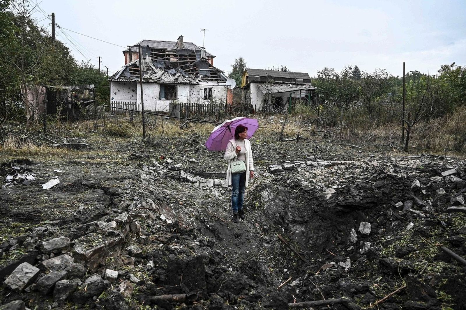 Женщина смотрит на большую воронку после российского обстрела. Город постоянно подвергается обстрелам. «Краматорск обстреливают авиацией и ракетами, только за вчера было больше шести ракет», — рассказал в понедельник мэр города Александр Гончаренко. 