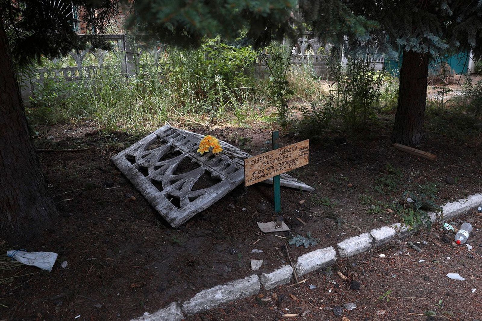 Могила жителя Северска, который был убит во время обстрела города и похоронен возле собственного дома. Российские войска пока не могут занять высоты возле города. 22 июля / Anatolii Stepanov / AFP / Scanpix / LETA / Meduza