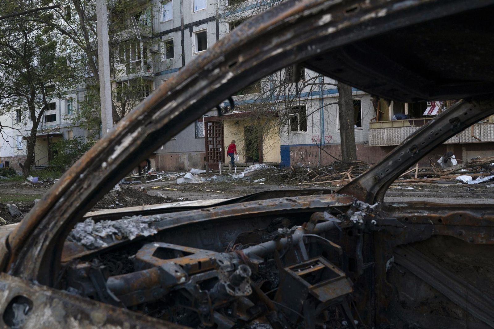 Женщина возвращается в свой дом, сильно поврежденный после обстрела со стороны российских войск в Запорожье. 16 октября / Leo Correa / AP