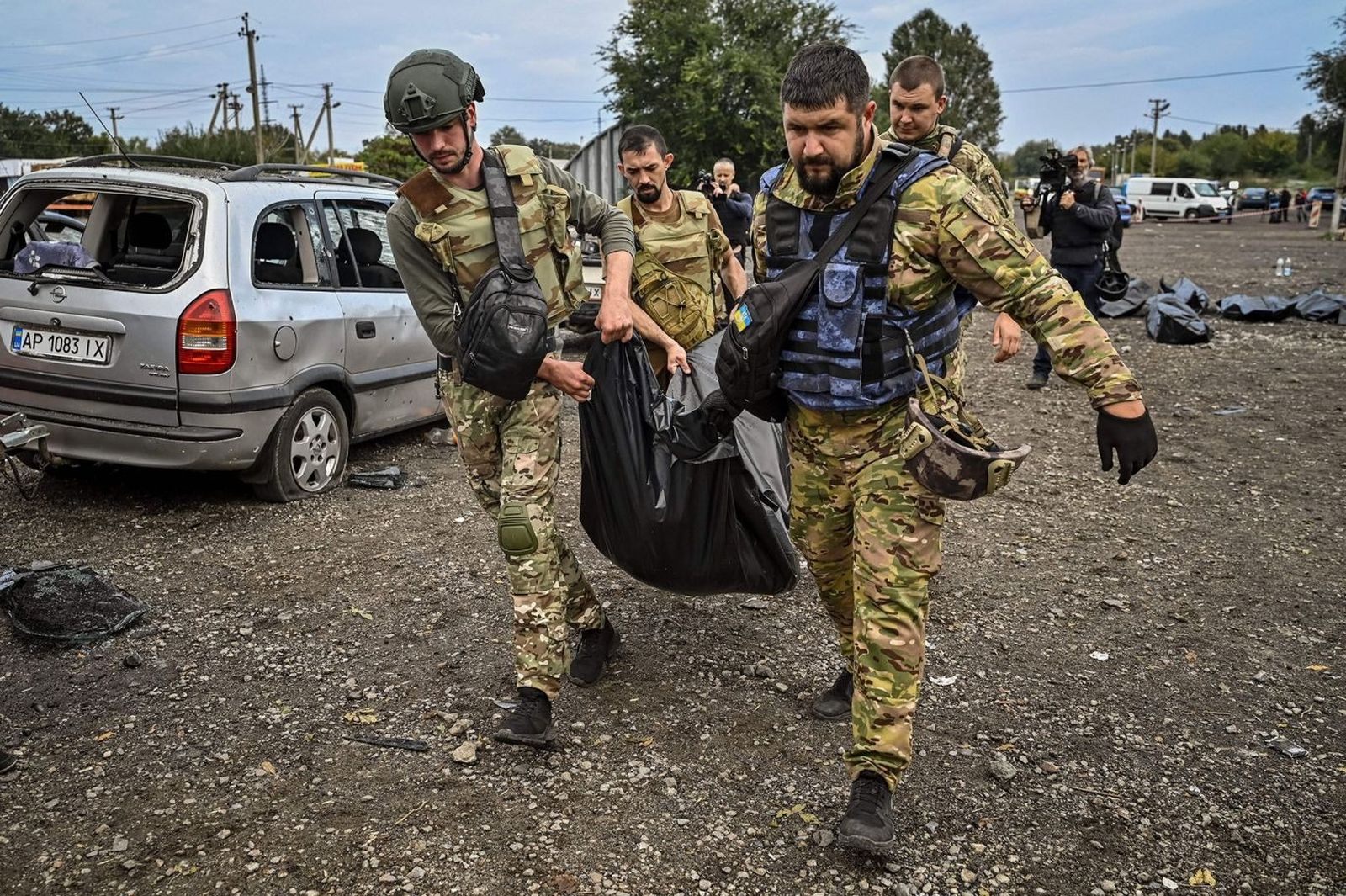Украинские военнослужащие собирают тела мирных граждан после ракетного удара по колонне гражданских автомобилей, в результате которого погибли не менее 30 человек под Запорожьем. 30 сентября / Genya Savilov / AFP / Getty Images / CNN