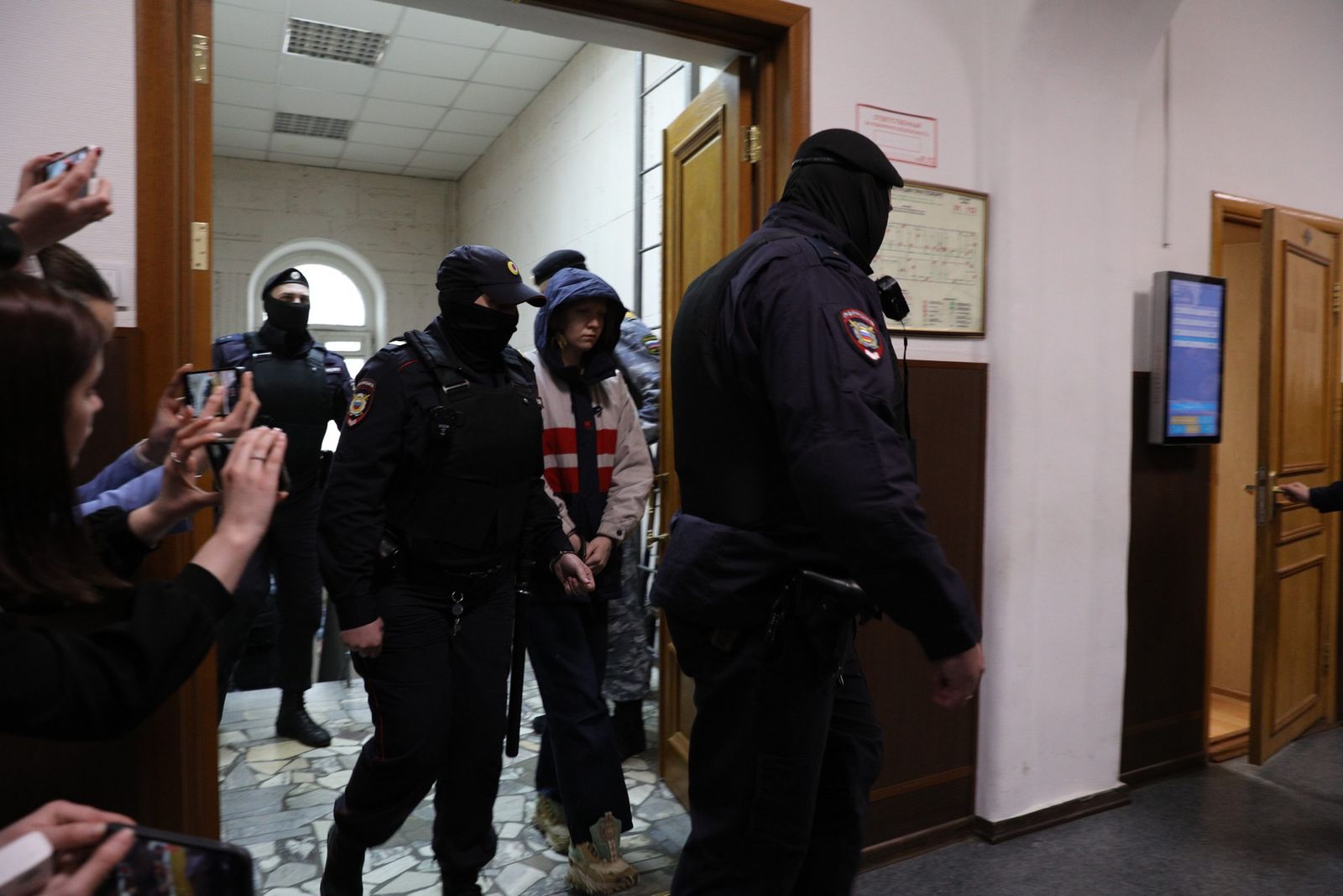 Подозреваемую в совершении убийства военкора Татарского Дарью Трепову заводят в зал суда. «Нахуй мы эту тварь снимаем вообще. Уебище», — передает Медиазона комментарий одного из присутствующих журналистов. 4 апреля / Александра Астахова / Медиазона