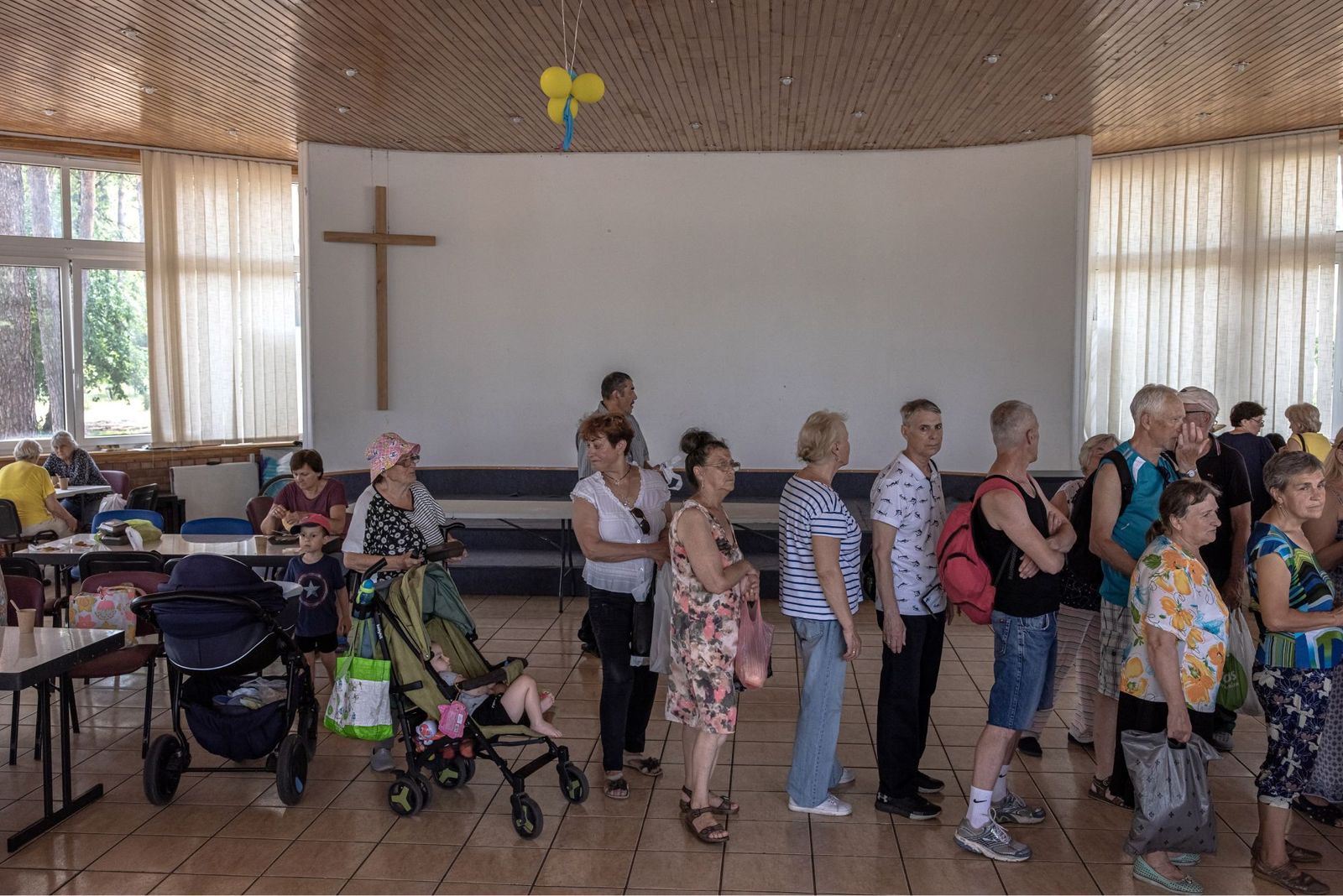 Жители Ирпеня и беженцы в очереди за хлебом в здании Библейской церкви. Этот город стоял на пути группы российских войск, наступавших на столицу со стороны Беларуси. Ирпень был частично оккупирован российской армией, которая заняла близлежащий аэропо