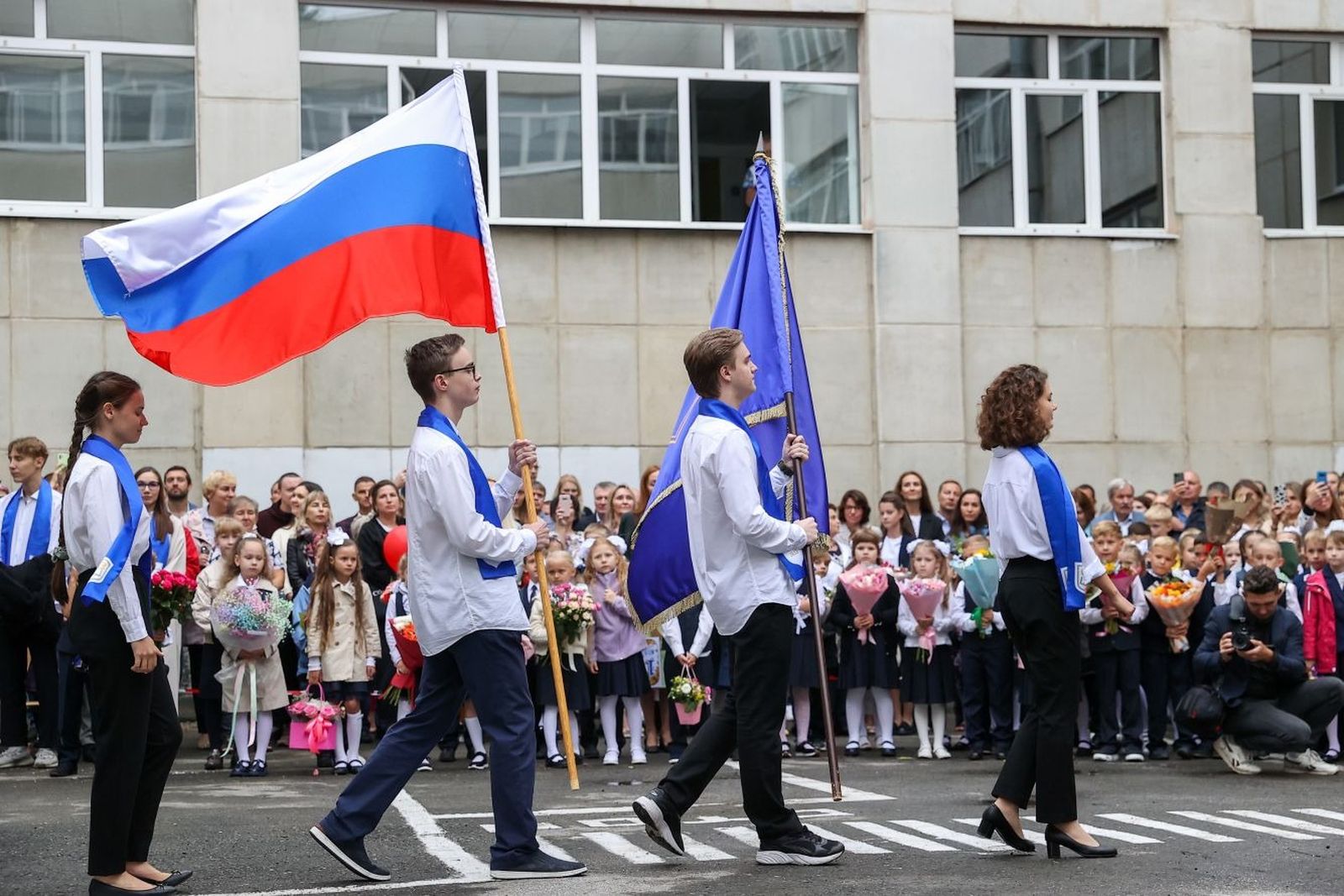 Российские школьники отмечают День знаний с новшествами от министерства просвещения. Теперь каждый понедельник будет начинаться с церемонии поднятия флага и исполнения гимна России. 1 сентября / Донат Сорокин / ТАСС / Meduza 