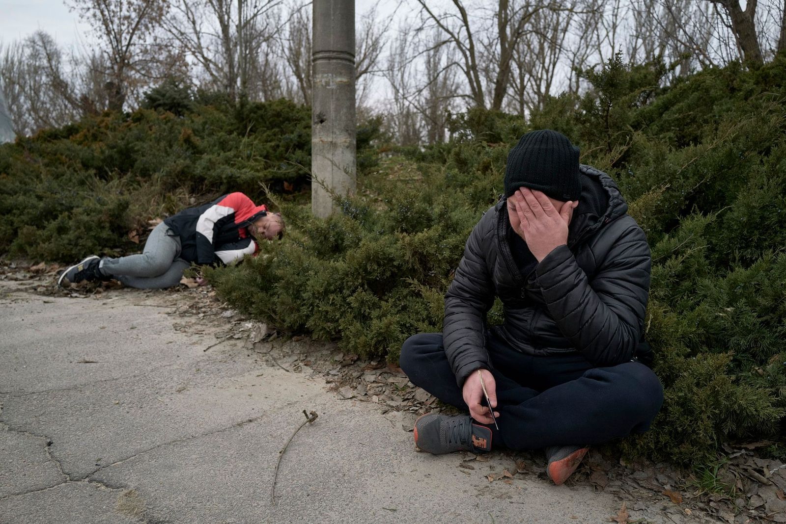 Мужчина сидит рядом с телом убитого друга. Он погиб во время российского артиллерийского обстрела Херсона Pierre Crom / Getty Images / Meduza