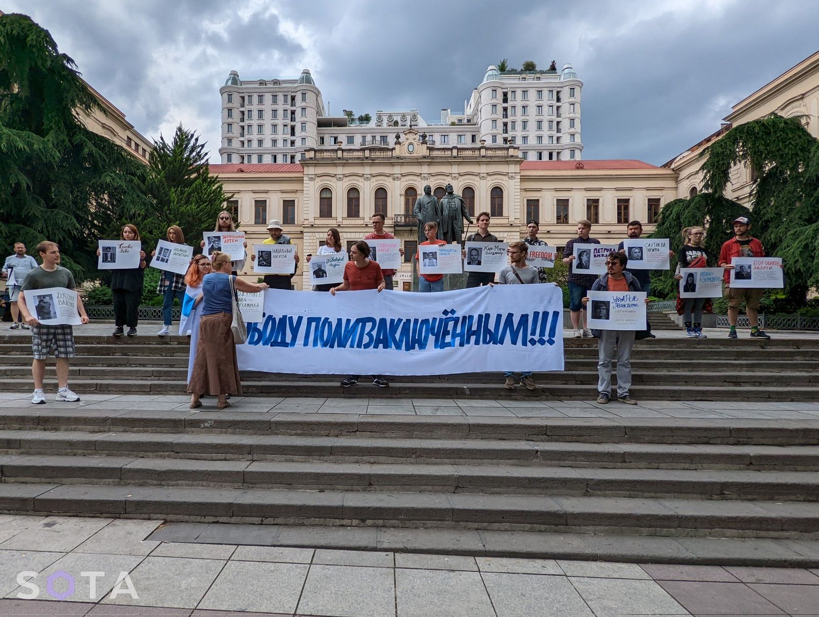 Демонстранты в Тбилиси держат плакаты, напоминающие о российских политзаключенных, находящихся в тюрьмах. Акцию недалеко от парламента Грузии провели участники движения «Русские в Сакартвело». 18 июня / SOTA
