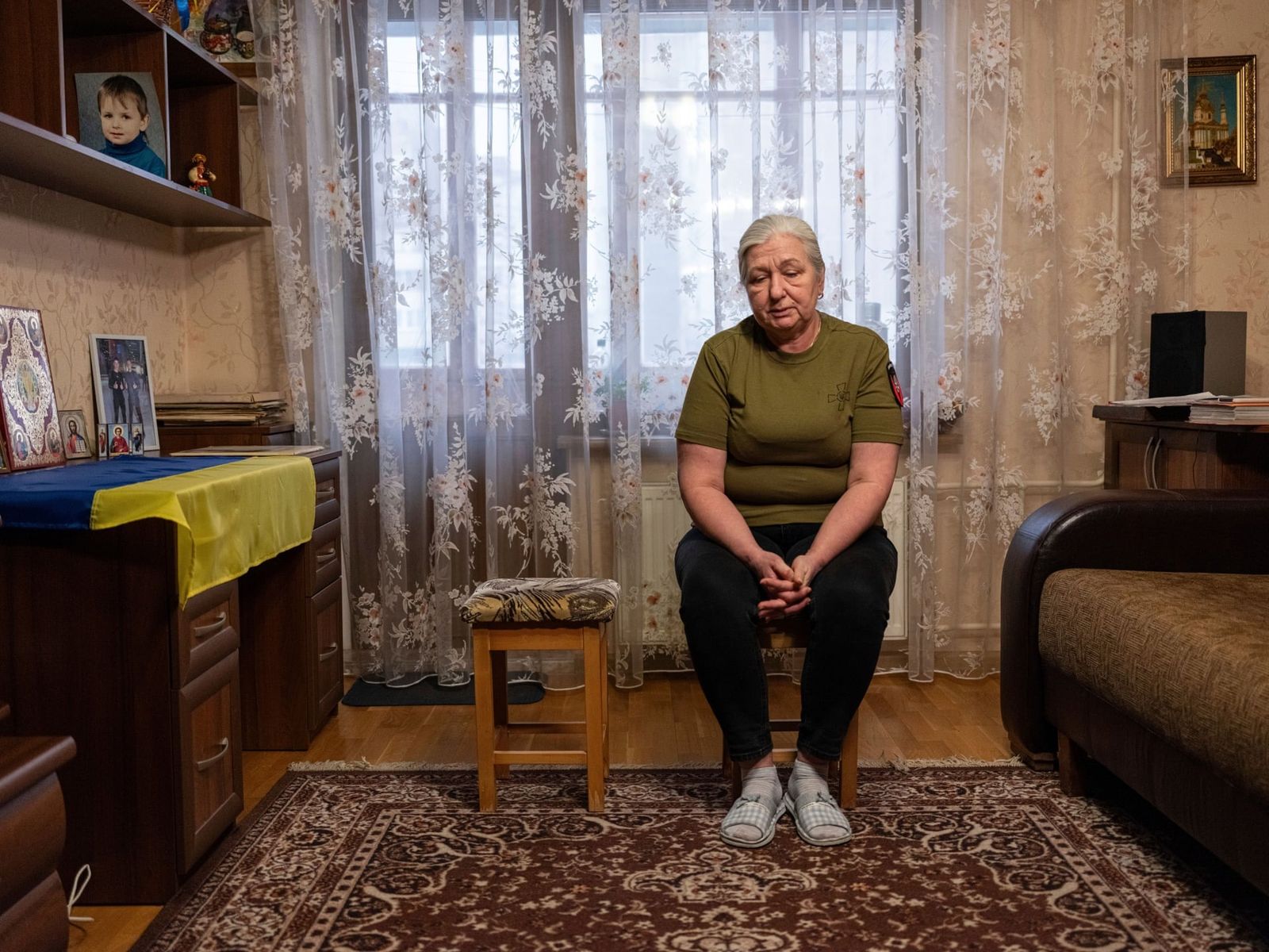 59-летняя Ирина Рева позирует для портрета фотографу Евгению Малолетке в своей квартире в Киеве. Её 25-летний сын Владислав пропал без вести во время боев в Донецкой области 24 июля 2022 года. Ее зять Александр Дыгало, служивший в 95-й бригаде, также