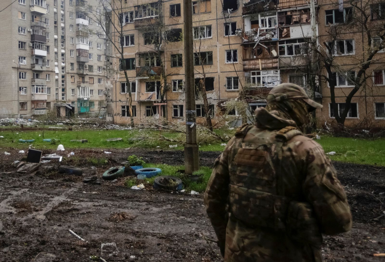 Украинский военнослужащий идет мимо поврежденных жилых зданий в Бахмуте в Донецкой области. 21 апреля / Анна Кудрявцева / Reuters