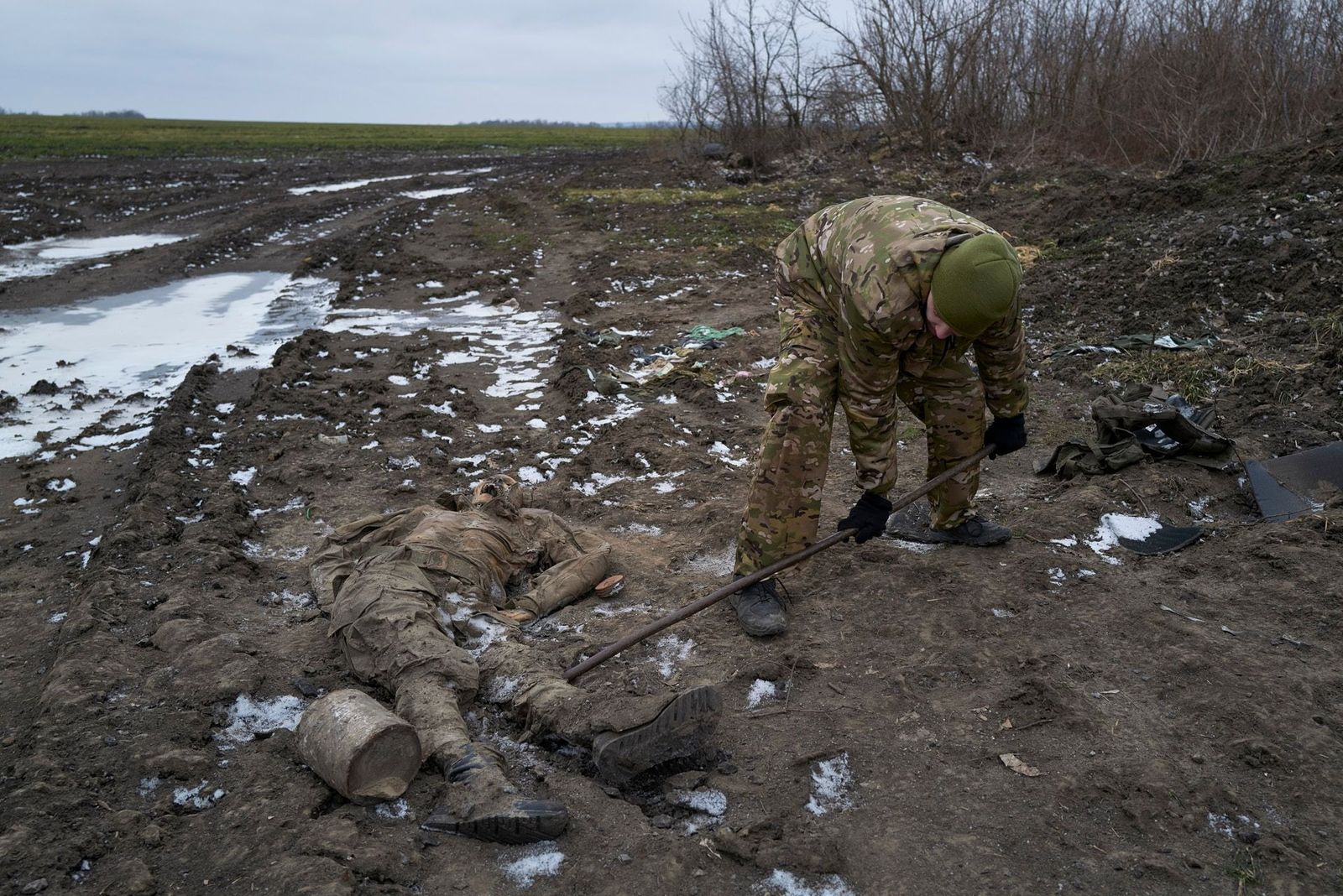 Украинский военный извлекает останки российского солдата из замерзшей грязи недалеко от села Куриловка, расположенного примерно в пяти километрах от поселка Купянск-Узловой, который перешел под контроль ВСУ 27 сентября 2022 года после шести месяцев р