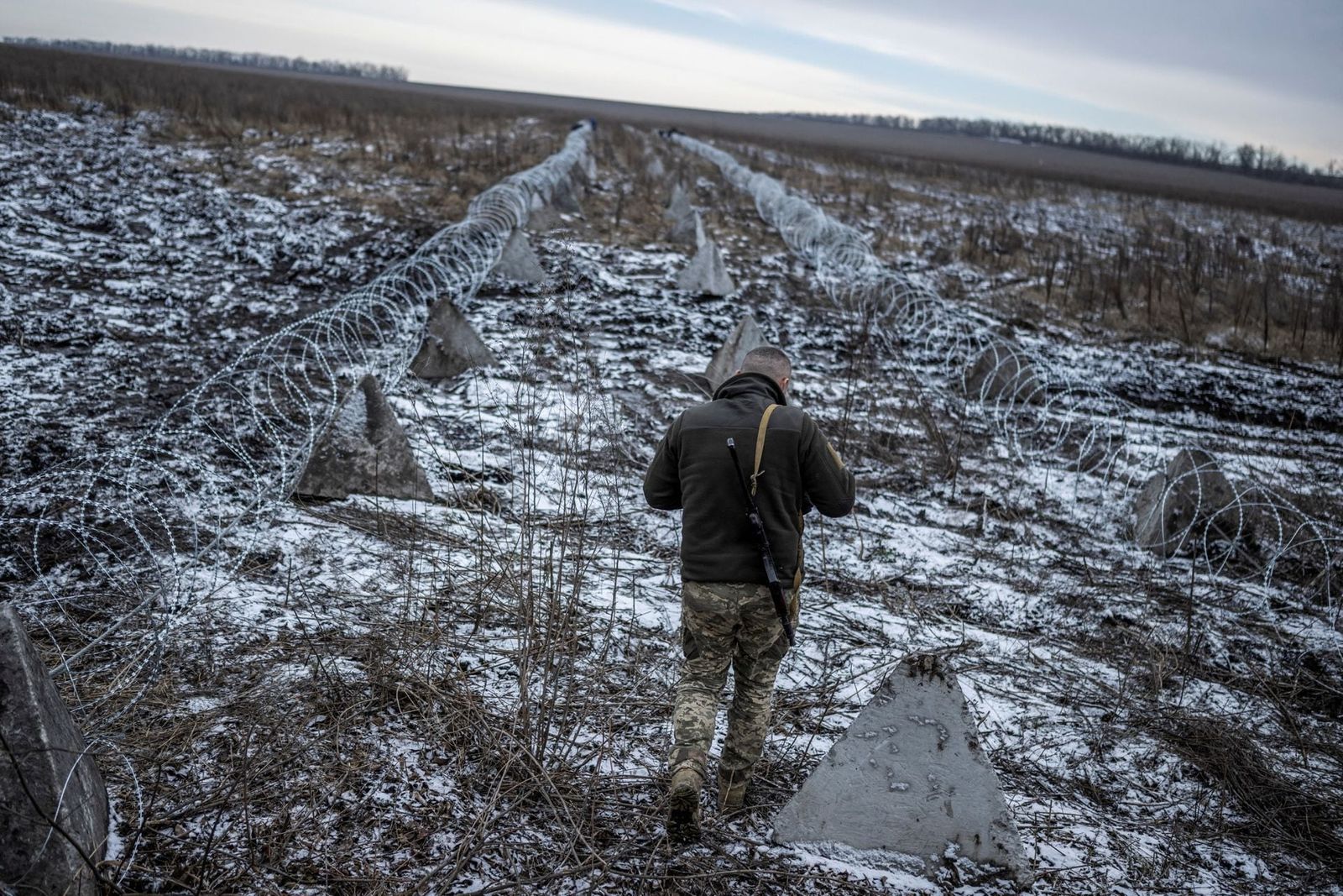 Украинский военнослужащий идёт вдоль защитных сооружений возле линии фронта в Харьковской области. После ухода в оборону ВСУ начали укреплять свои позиции в Харьковской области. Британская газета The Telegraph утверждает, что возведение аналога «лини