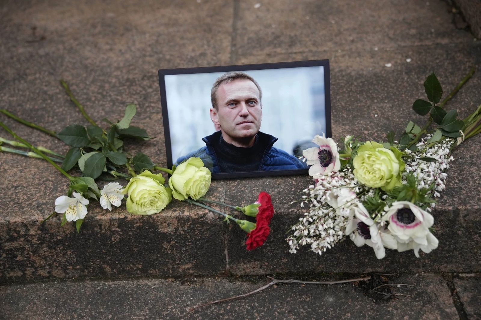 Портрет Алексея Навального и цветы возле посольства России во Франции. 16 февраля / Christophe Ena / AP Photo