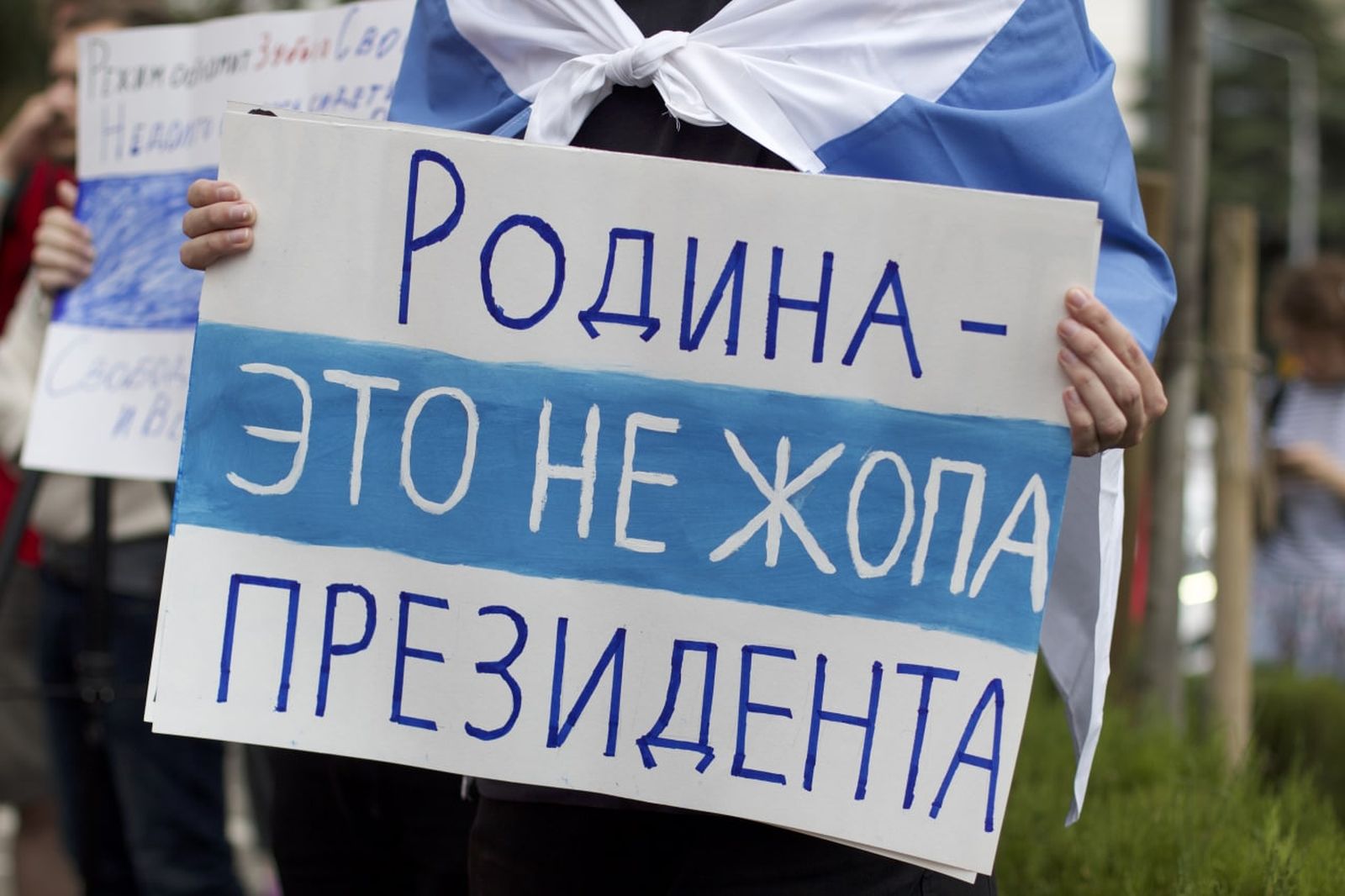 Демонстрант держит плакат на антивоенном митинге в Тбилиси, содержащий цитату лидера группы «ДДТ» Юрия Шевчука. На своём концерте в Уфе музыкант произнёс слова о родине, после чего на него составили протокол о дискредитации российской армии. Позднее 