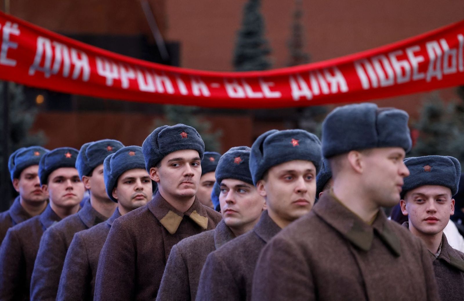 Участники выставки, посвященной годовщине исторического парада 1941 года, на Красной площади. Лозунг на баннере гласит: «Все для линии фронта, все для победы». 8 ноября / Maxim Shemetov / Reuters