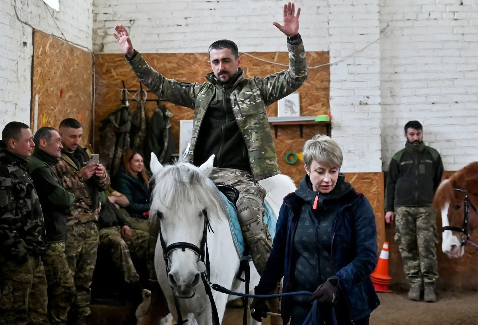 Украинские солдаты отдыхают от боя. В конюшне под Киевом им проводят иппотерапию для достижения терапевтического эффекта. 20 марта / Sergei Supinsky / AFP / Getty Images / The Guardian 