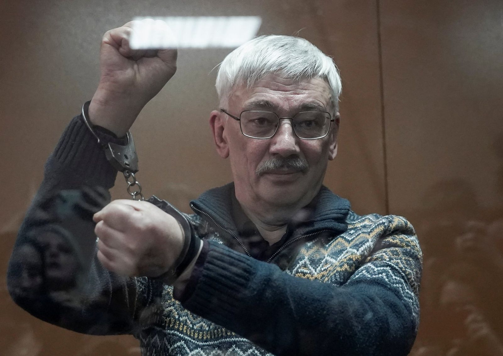 Российский правозащитник Олег Орлов стоит за стеклянной стеной во время заседания суда. Орлов был приговорен к двум с половиной годам лишения свободы после того, как его признали виновным в дискредитации вооруженных сил России. 27 февраля /  Tatyana 