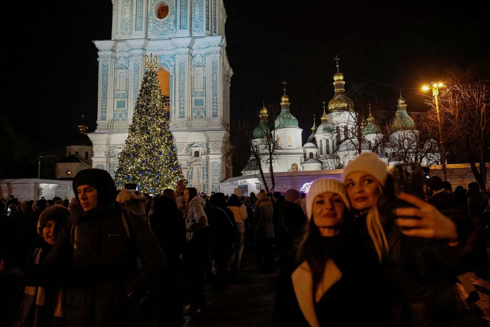 Люди делают селфи с рождественской елкой перед Софийским собором в Киеве. 7 декабря / Alina Smutko / Reuters