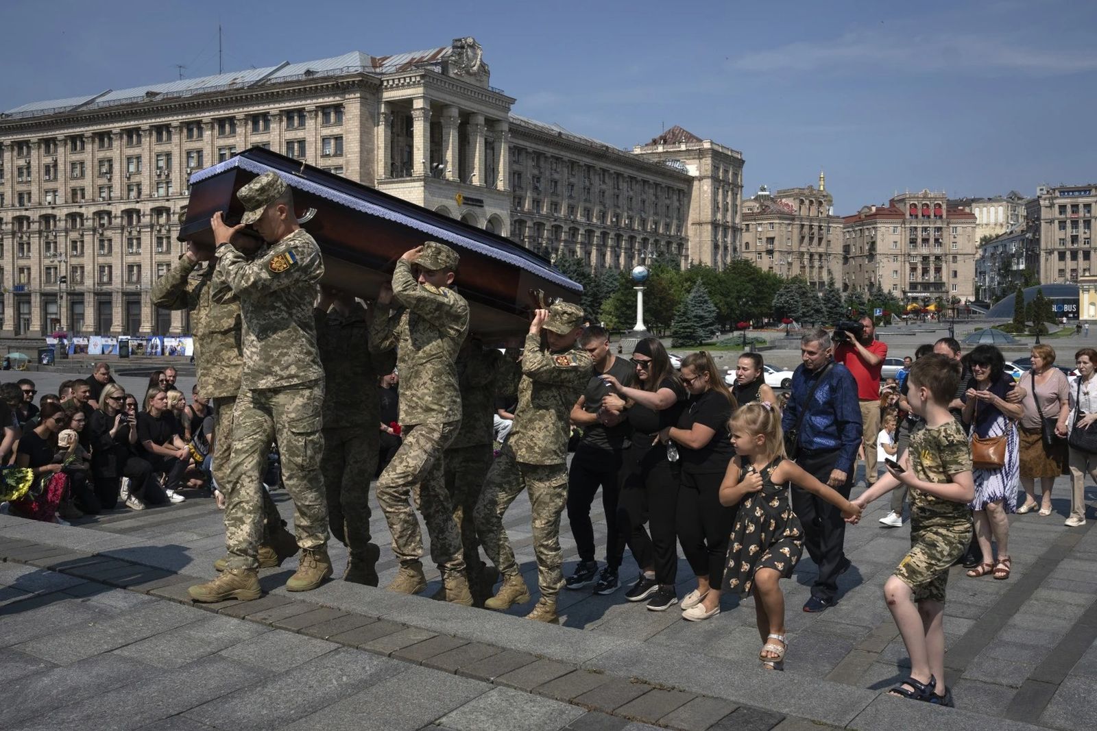 Украинцы преклоняют колени в знак солидарности с погибшим под Бахмутом солдатом-добровольцем Иваном Шульгой во время церемонии прощания в Киеве. До войны мужчина занимался звукорежиссурой на телевидении и музыкой.  June 20 / Efrem Lukatsky / AP Photo