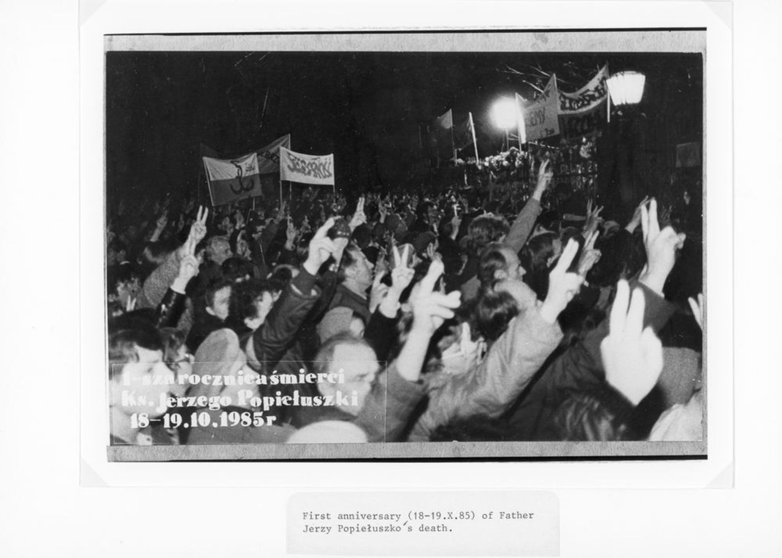 Демонстрация возле церкви святого Станислава Костки в Варшаве первую годовщину смерти отца Ежи Попелушко в 1985 году. Участники поднимают руки с пальцами в форме V( Victoria), что было символом мирного сопротивления и надежды на победу «Солидарности». Фото из архивов института национальной памяти, Польша (IPN)