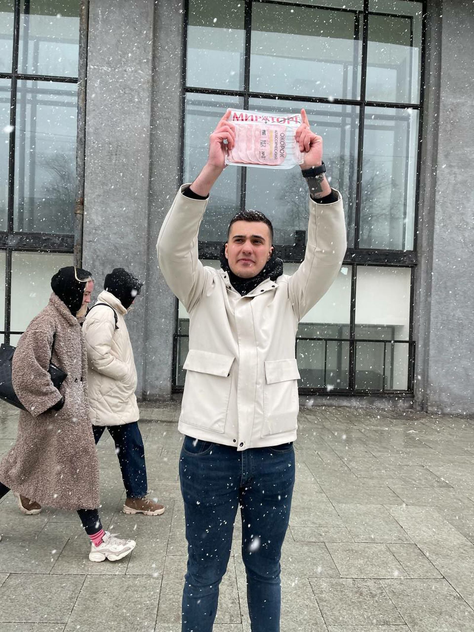 Мужчина во время одиночного пикета держит упаковку с колбасой марки «Мираторг», на которой зачёркнута половина слова. Акционера задержала полиция и составила на него протокол по статье о дискредитации вооружённых сил РФ. «Гражданин использовал упаков