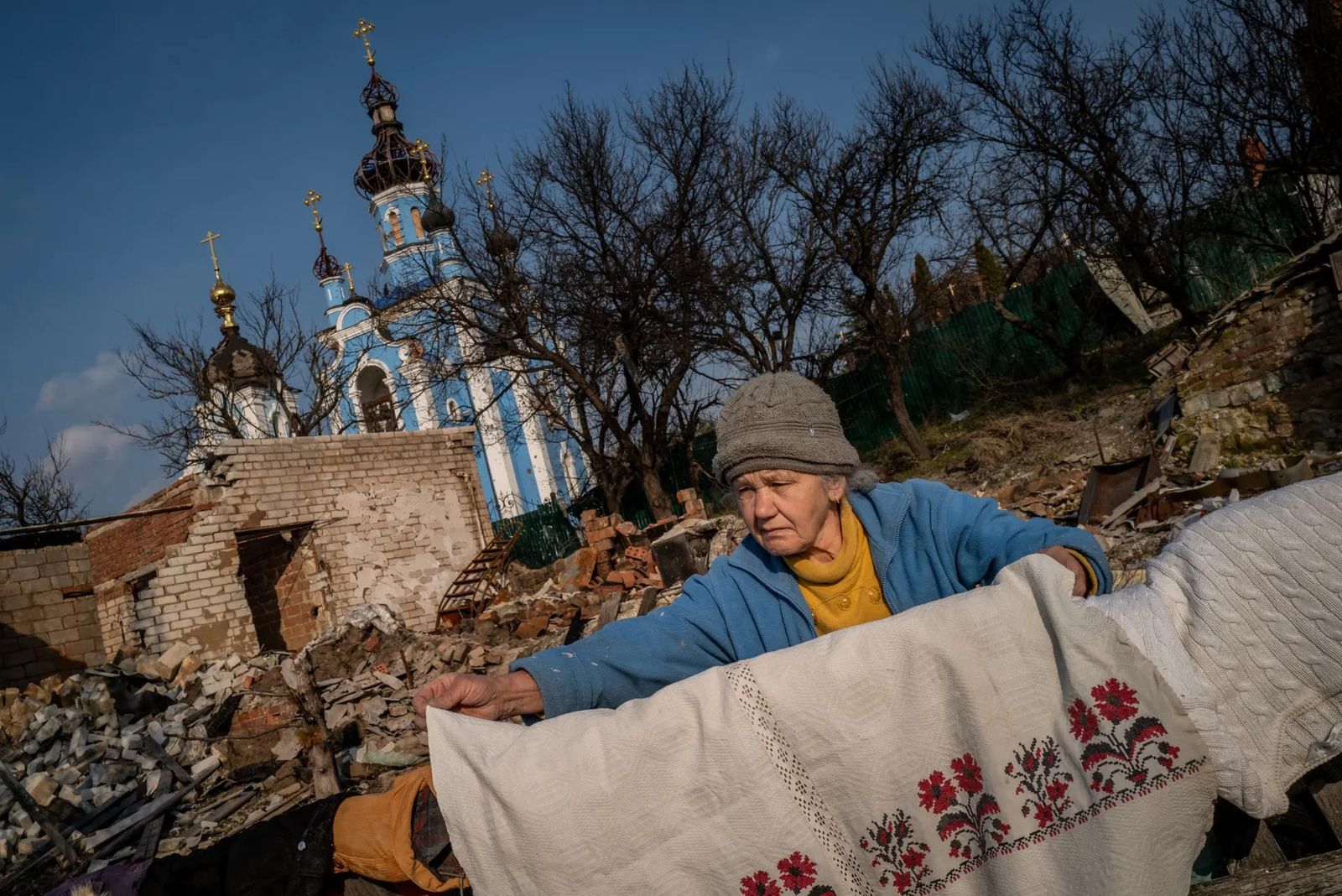 67-летняя Любовь Егоровна сушит вещи возле своего разрушенного дома в селе Богородичное (Донецкая область). Летом 2022 года в этом районе шли интенсивные бои, и еще в августе село оставалось под контролем российской армии, но в сентябре в ходе контрн