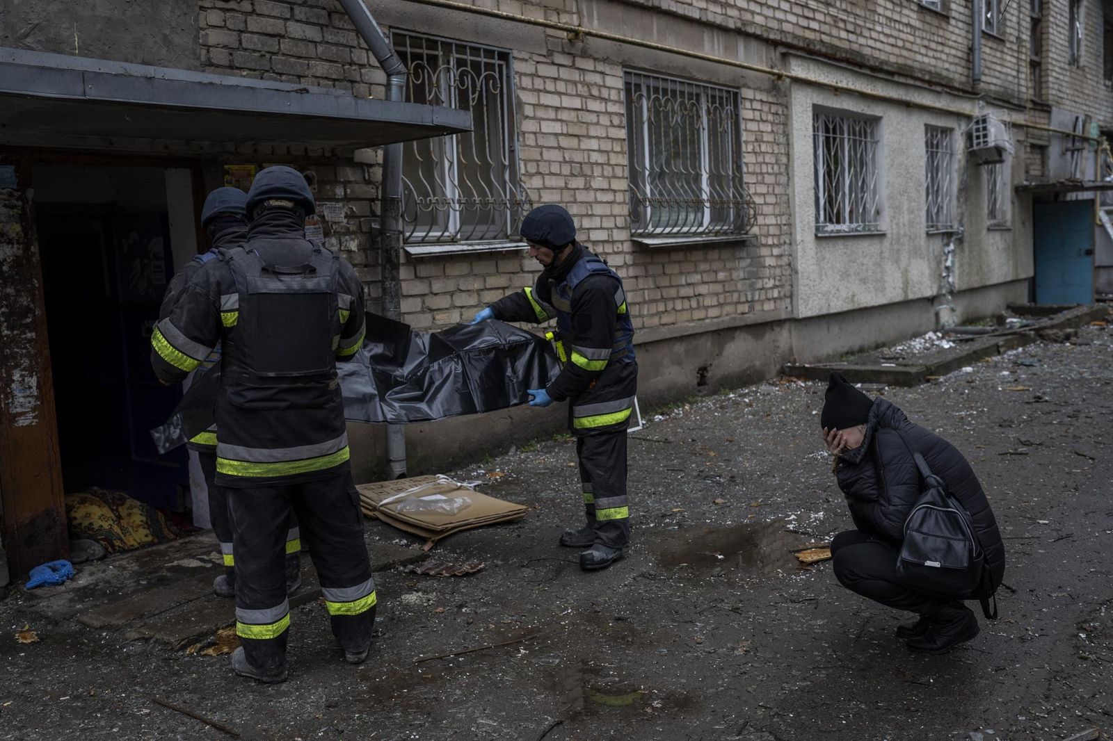 38-летняя Лилия Кристенко плачет, глядя на то, как городские спасатели забирают тело ее матери Натальи Кристенко. Мертвое тело Натальи Кристенко лежало в одеяле в дверях ее многоквартирного дома в течение нескольких часов. 62-летняя женщина выходила 