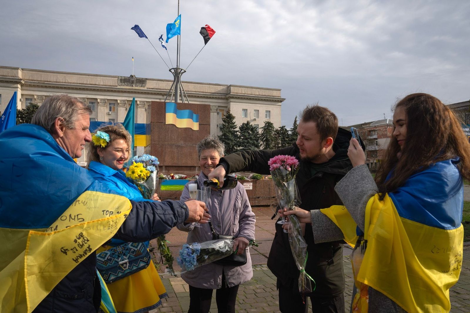 Жители Херсона с цветами и шампанским празднуют годовщину освобождения на главной площади города. 11 ноября / Efrem Lukatsky / AP Photo