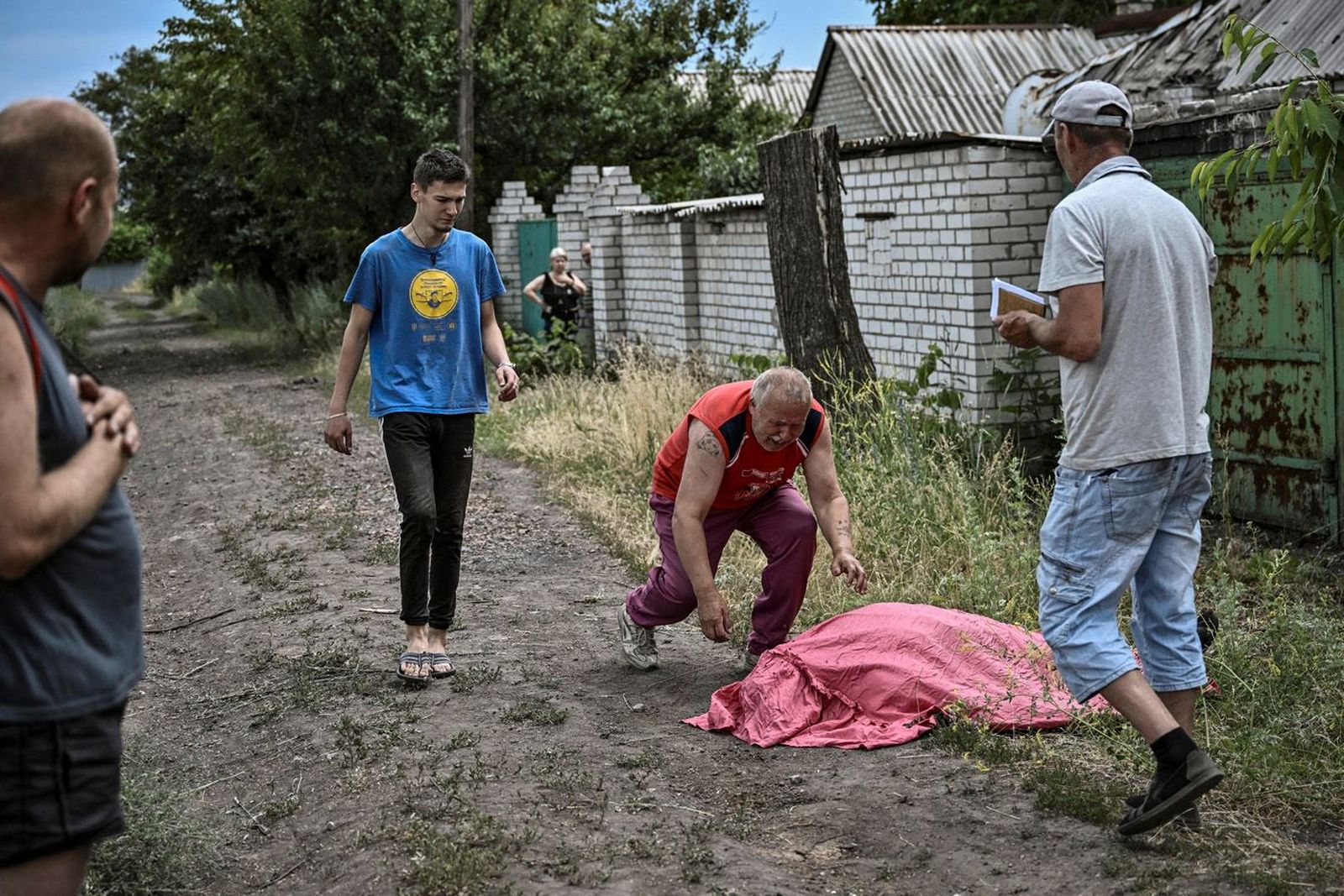 Мужчина видит тело своего сына, убитого кассетной ракетой в Лисичанске. Обстрелы города продолжаются, сообщает Генштаб ВСУ. 18 июня / Aris Messinis / AFP / Scanpix / LETA / Meduza