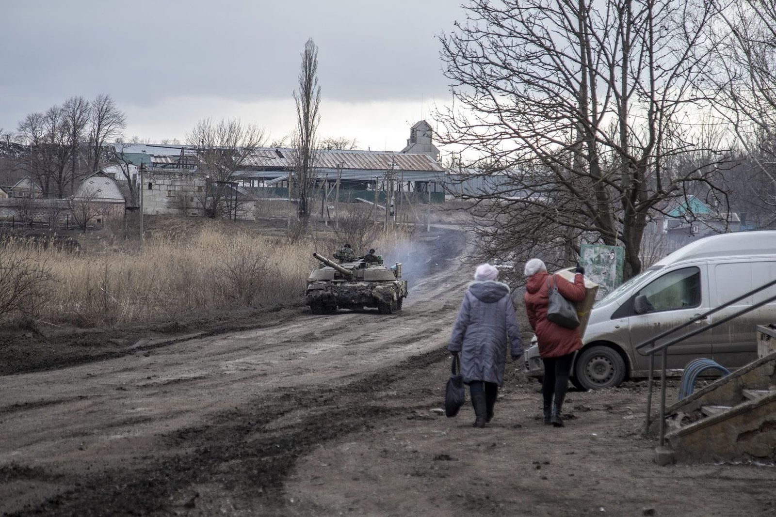 Мирные жители и танк отступающих украинских военных на дороге в селе Первая Новоселовка в 20 километрах к северо-западу от Авдеевки. 21 февраля / Narciso Contreras / Anadolu