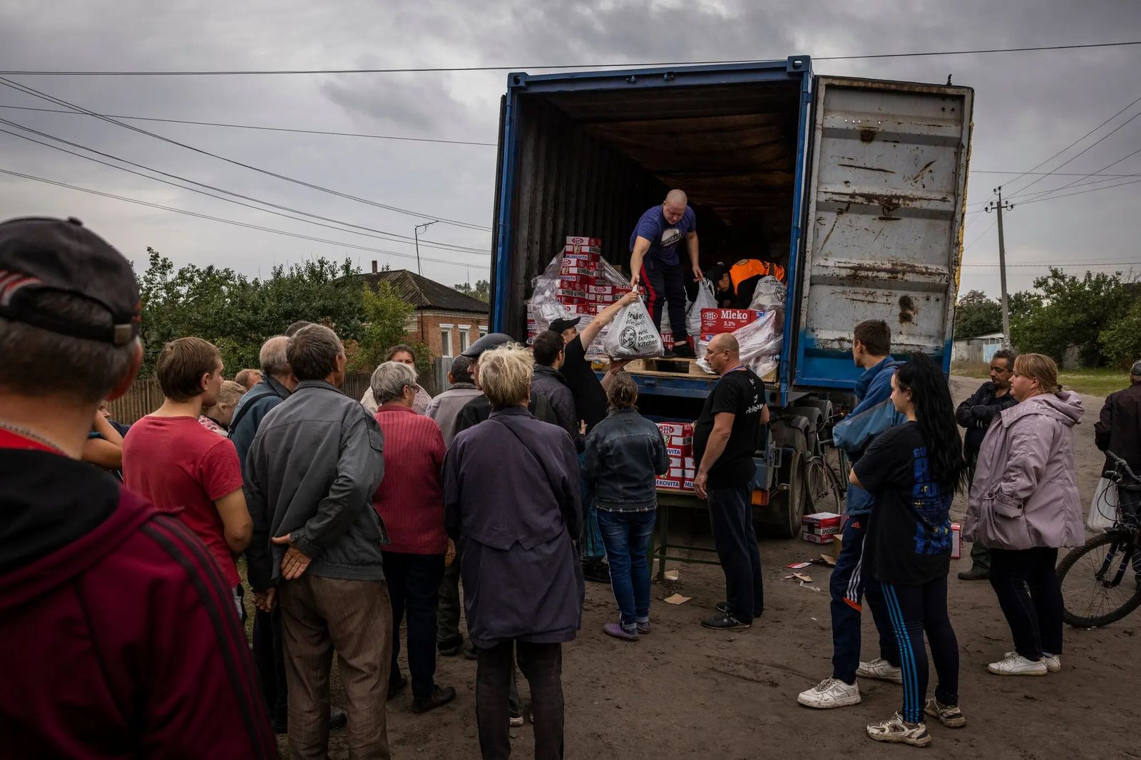 Люди выстроили в очередь за гуманитарной помощью на окраине Изюма, который недавно освободили украинские войска. 2 октября / Ivor Prickett / The New York Times