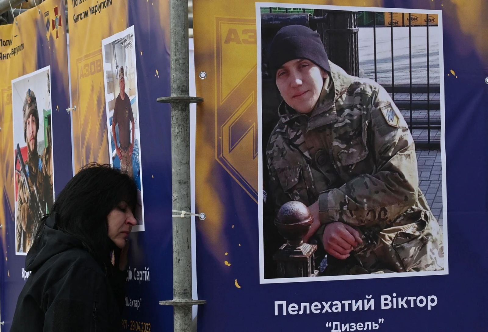 Родственница погибшего военнослужащего прислонилась к его портрету во время открытия в Киеве выставки «Полк Азов - Ангелы Мариуполя» ко Дню защитника Украины. 14 октября / Sergei Supinsky /AFP via Getty Images / Grid