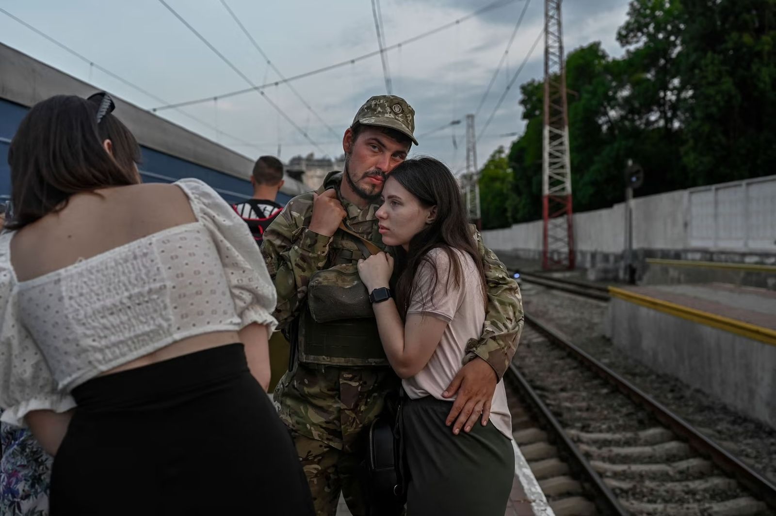 Украинский солдат обнимает свою супругу перед посадкой в ​​поезд до Днепра на вокзале в Одессе. 24 июля / Bulent Kilic / AFP / Getty Images / Atlantic