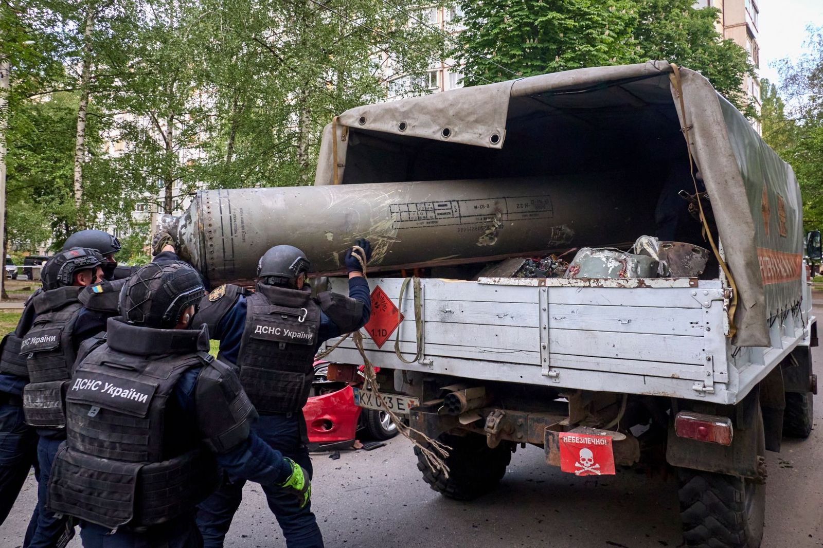 Сотрудники ГСЧС Украины убирают обломок российской ракеты от ЗРК С-300, выпущенной войсками РФ по Харькову. 14 мая / Sergey Kozlov / EPA / Scanpix / LETA / Meduza
