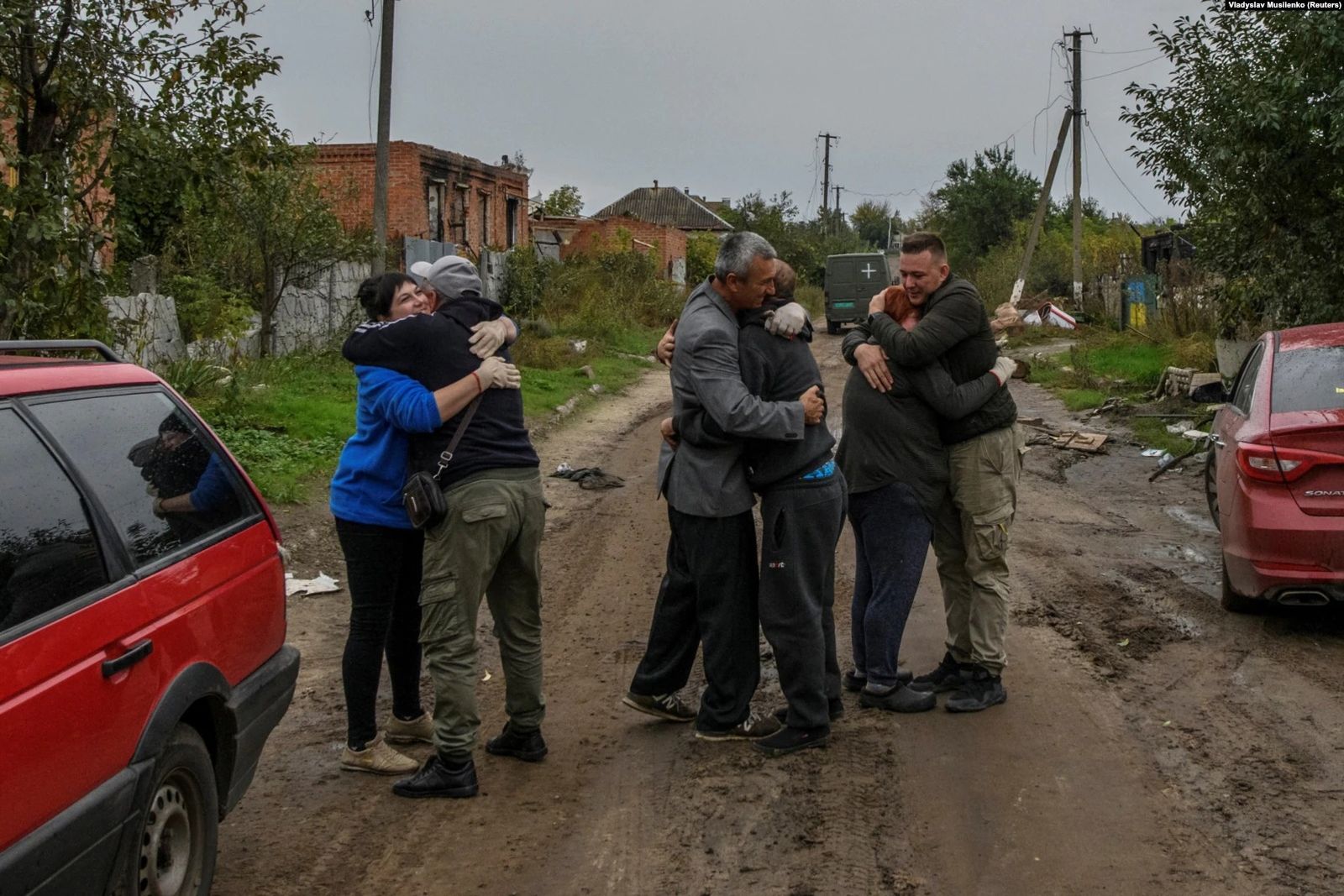 Соседи обнимают друг друга после возвращения в село Каменка Харьковской области, освобожденное от российских войск. 2 октября / Vladyslav Muslienko / Radio Liberty