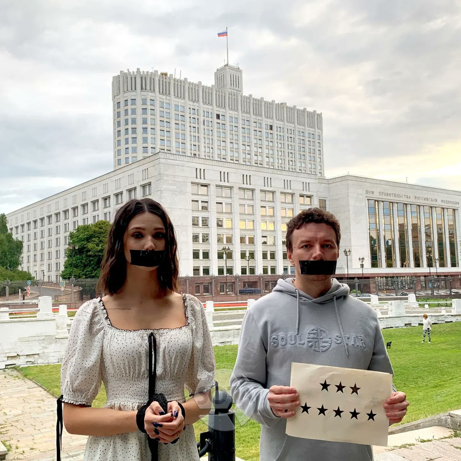 Кандидаты в муниципальные депутаты Сергей Смирнов и Мария Волох проводят антивоенную акцию с заклееными ртами у Дома правительства в Москве. Как сообщает SOTA, активисты не были задержаны. 20 июля / SOTA