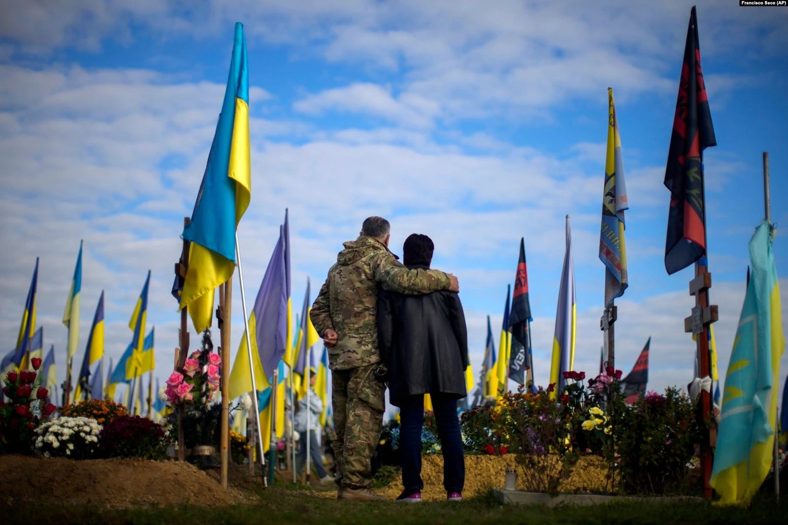 Родители недавно убитого украинского солдата Руслана Жумабоева стоят у его могилы на харьковском кладбище во время Дня защитников Украины. 14 октября / Francisci Seco / AP / Radio Liberty