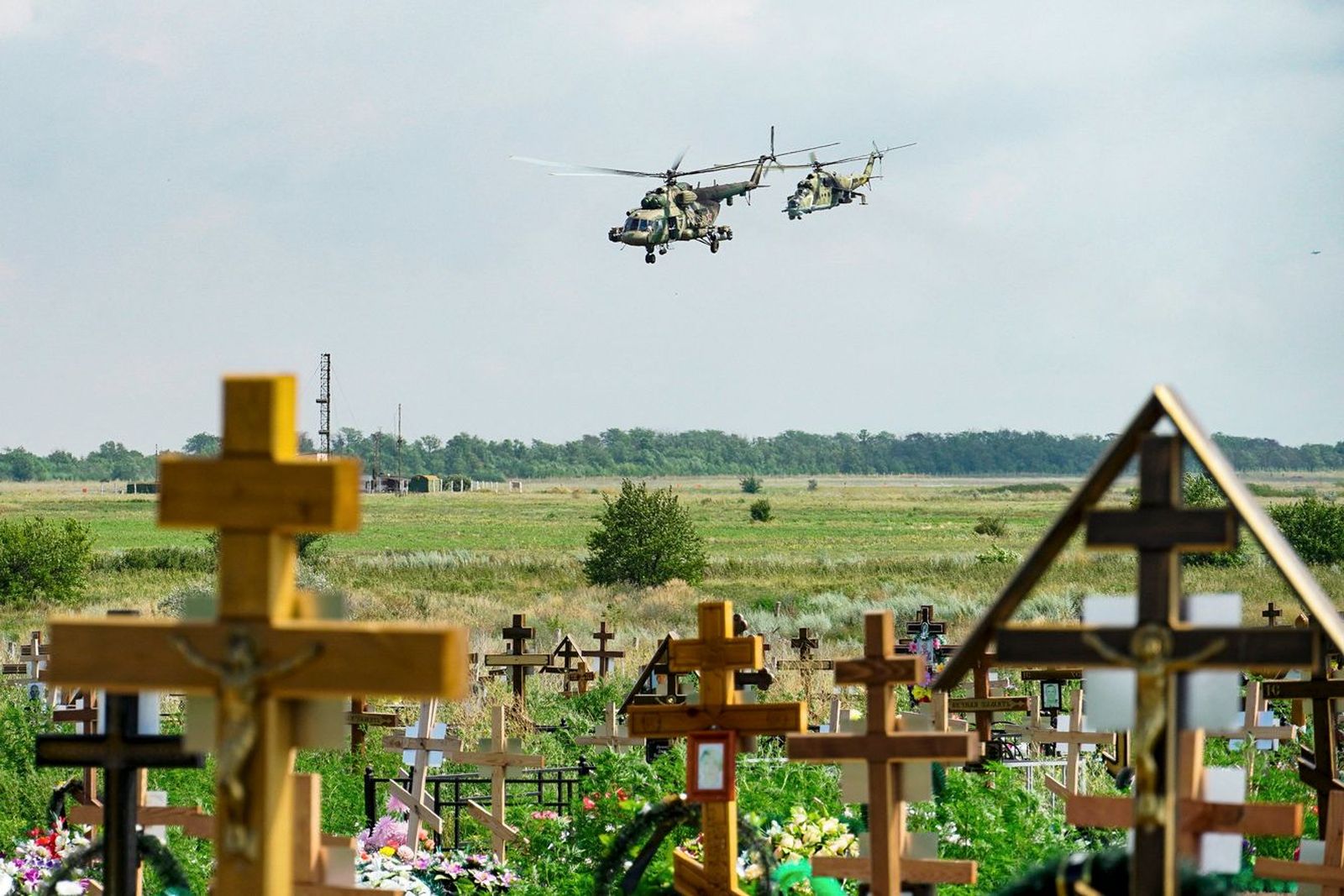 Вертолеты с буквой Z на борту летят над кладбищем в Ростовской области на границе с Украиной. Недалеко от этого места находится военный аэродром Таганрог-Центральный. Министерство обороны не сообщает о своих потерях с конца марта. По открытым данным,