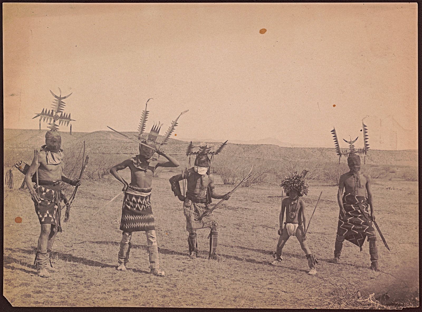 Танец Дьявола, 1899. Танцоры-дьяволы апачи (возможно, из группы чирикауа) в головных уборах, масках, одеялах и с оружием. Фотограф Кэтрин Тейлор Додж. Библиотека Конгресса США, Вашингтон.