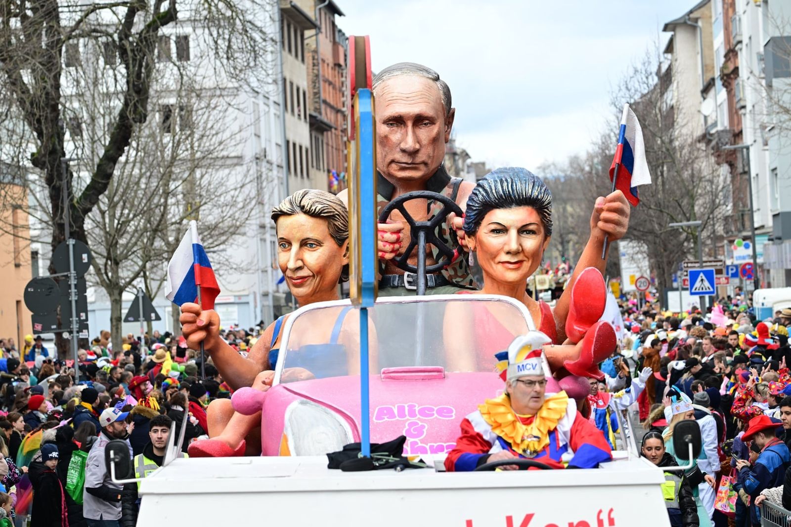 Парадный флаг изображает Алису Вайдель из ультраправой партии AfD и Сару Вагенкнехт в виде куклы Барби в автомобиле, за рулём которого Владимир Путин. Такая сатирическая инсталляция появилась на ежегодном карнавальном параде «Розовый понедельник» в н