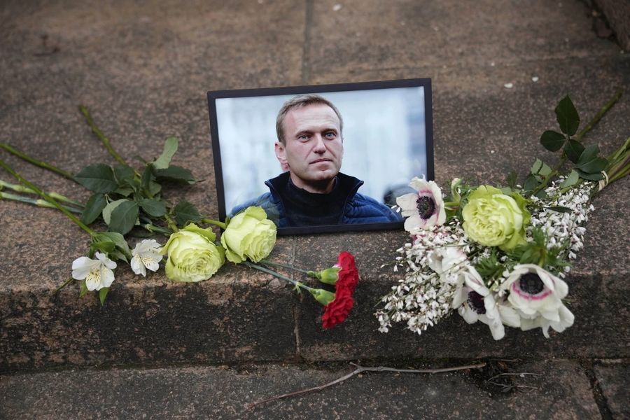 Портрет Алексея Навального и цветы возле посольства России во Франции. 16 февраля / Christophe Ena / AP Photo / Фотохроника войны. Главные кадры февраля: Навальный убит, Белгород обстреливают, ВСУ отступают из Авдеевки — Discours.io