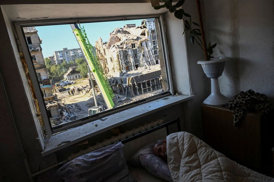 Житель Покровска пытается уснуть внутри поврежденного жилого дома во время утренних обстрелов. 8 августа / Viacheslav Ratynskyi / Reuters / The Guardian / Фотохроника войны. Главные кадры августа: День независимости Украины, похороны Пригожина и массовые удары по России — Discours.io
