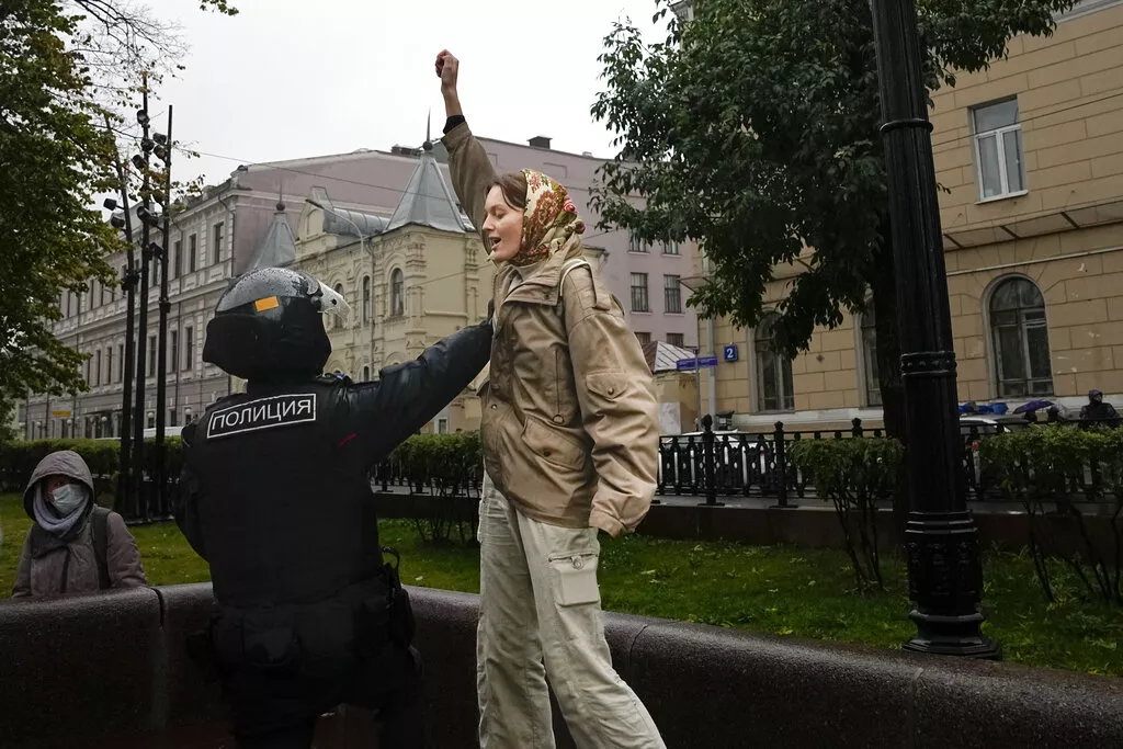 Полицейский задерживает девушку на протестной акции в Москве 24 сентября / Фото: АР